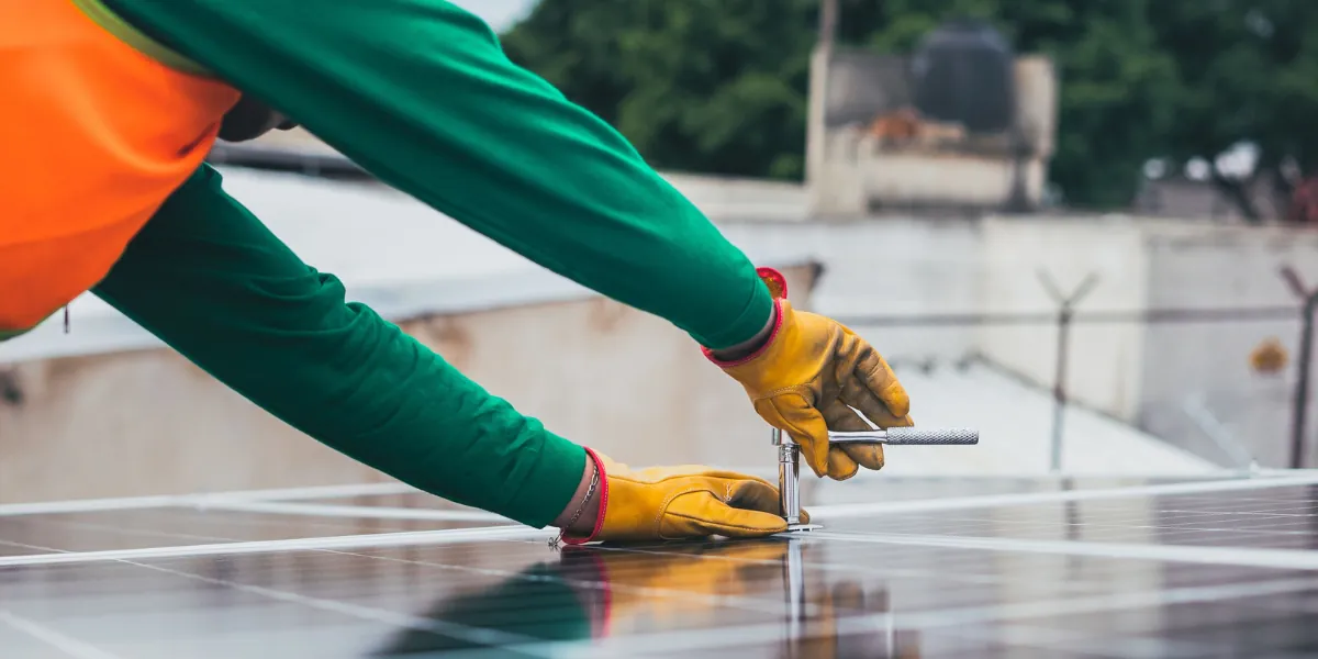 Monteur bevestigt zonnepanelen op het dak tijdens de installatie